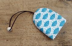 a blue and white heart shaped pouch sitting on top of a wooden table next to a string