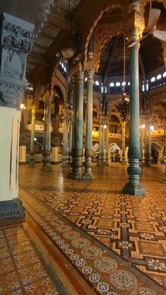 the inside of an ornate building with columns and tile flooring on it's sides