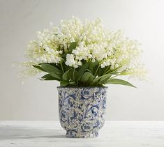 a blue and white vase with flowers in it