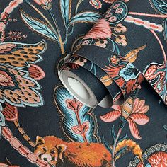 a roll of black and red floral wallpaper with an animal design on it's side