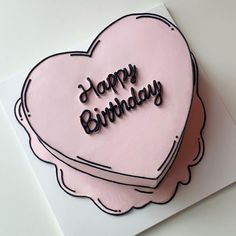 a pink heart shaped cake with the words happy birthday written on it's side