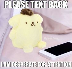 a stuffed animal sitting next to a cell phone