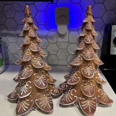 two small christmas trees sitting on top of a counter