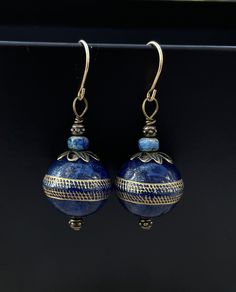 Midnight blue spheres flecked with gold mimic the mystique and elegance of Lapis Lazuli without the weight. Luxurious yet lightweight, they have an equator of gold gilding. The earrings dangle 1.75 inches and are accented by delicate Czech crystal faceted beads and bronze lacework cap beads.  The french hook earwires are 14k goldfill and are perfect for those with any metal sensitivities. Blue Round Earrings For Formal Occasions, Blue Round Earrings For Pierced Ears, Elegant Etched Round Earrings, Formal Blue Round Earrings, Blue Teardrop Brass Earrings, Blue Round Brass Jewelry, Blue Brass Round Jewelry, Blue Traditional Earrings For Formal Occasions, Traditional Blue Earrings For Formal Occasion