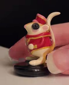 a tiny figurine sitting on top of a finger