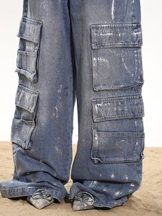 Stay on trend with these relaxed baggy cargo denim pants. Featuring a wide leg and cargo pockets for practicality, add some edge to your look with the paint splatter and distressed details. Relaxed, baggy fit Wide leg silhouette Multiple oversized cargo pockets Distressed blue wash with paint splatter effect Model is 5'4 95lbs wearing M Baggy Medium Wash Cargo Jeans In Grunge Style, Baggy Grunge Cargo Jeans In Medium Wash, Grunge Medium Wash Cargo Jeans For Streetwear, Distressed Denim Blue Cargo Jeans In Grunge Style, Distressed Denim Blue Grunge Cargo Jeans, Grunge Wide-leg Jeans With Cargo Pockets, Grunge Wide-leg Denim Cargo Jeans, Grunge Wide Leg Denim Cargo Jeans, Grunge Wide Leg Jeans With Cargo Pockets