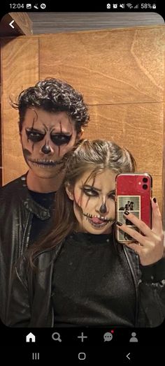 two people with painted faces taking a selfie