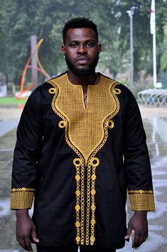 This men's  African Print Wakanda style 100% black polished cotton shirt with gold embroidery is perfect for any special occasion such as traditional celebrations, events, weddings or proms, etc. The embroidery and excellent finishing helps to give a royal look the embroidery or the cuff of the arms really helps to set the look Wash at 30 degrees. Wash similar colours, Hand wash for first wash. Also comes in sizes  S- 42 M - 44, L 46 , XL - 48, XXL 50 XXXL- 52  4XL - 54 . Delivery will be between 2 to 3 weeks for tailor-made products   A matching female one is also available to be made to match the shirt , please let me know the sizes and ill update you on prices Black Embroidered Long Sleeve Shirt, Traditional Black Long Sleeve Shirt, Traditional Long Sleeve Shirt With Patterns, Traditional Long Sleeve Black Shirt, Gold Long Sleeve Cotton Shirt, Gold Kurta With Traditional Patterns For Ceremonies, Long Sleeve Embroidered Shirt For Festivals, Elegant Black Festive Shirt, Black Kurta With Gold Embroidery For Festivals