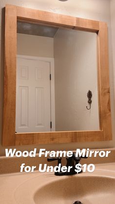 a bathroom sink under a large mirror in front of a white door with a black faucet