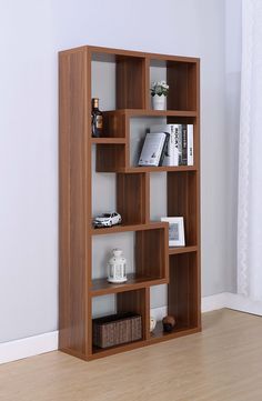 a wooden book shelf with books on it in a room next to a white wall