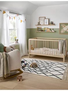 a baby's room with a rocking chair, crib and rug in it