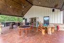 the inside of a house with wood floors and tables in front of large sliding glass doors