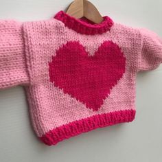 a pink knitted sweater with a heart on it