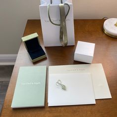 an assortment of items on a table including a ring, notepad and gift bag