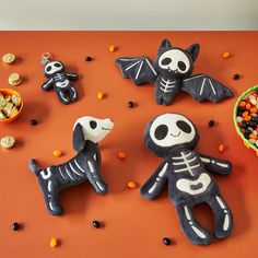 halloween treats made to look like skeleton dogs and cats on an orange table with candy