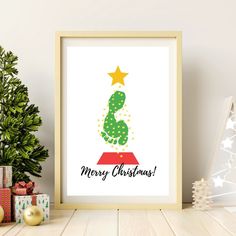 a christmas tree with the words merry christmas on it in front of presents and a potted plant