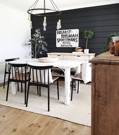 a dining room table with chairs and a sign on the wall