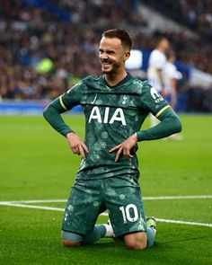 a soccer player sitting on the ground with his hands on his hips and looking at the camera