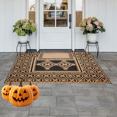 two pumpkins sitting on the front steps of a house with flowers and potted plants