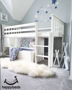 a white bunk bed sitting in a bedroom next to a wall with stars on it