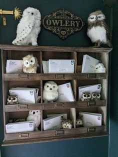 stuffed owls are sitting on top of an old book shelf