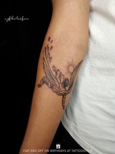 a woman's arm with a tattoo on it that has a bird and flowers on it