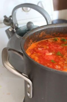 a pot filled with soup sitting on top of a stove