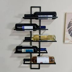 a wall mounted wine rack with several bottles on it and a painting hanging in the background