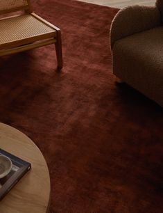 a living room filled with furniture and a coffee table in front of a chair on top of a rug