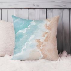 a decorative pillow on top of a white fur covered bed next to a wooden headboard