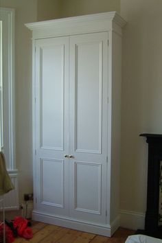 a white armoire sitting in the corner of a room