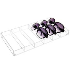 six pairs of sunglasses sitting on top of a clear display case with purple tinted lenses