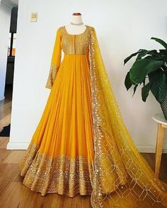 a mannequin is dressed in an orange and gold lehenga