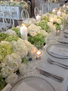 the table is set with white flowers and candles