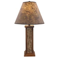 a lamp that is sitting on top of a wooden stand with a brown shade over it