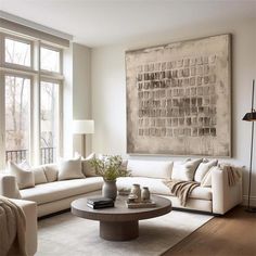 a living room filled with furniture and a large painting hanging on the wall above it