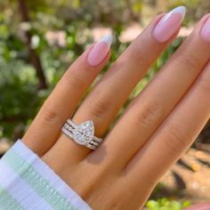 a woman's hand with two rings on her fingers and one ring in the middle