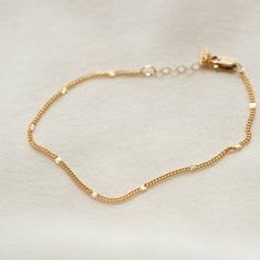 "The anklet that shines like summer incarnate. Each chain is dotted with little sunbursts to catch the light--like fireflies, twinkling lights and golden hour all rolled into one! Style it solo, stack with other anklets or add your favorite charm for an extra sparkle of personalization. Every piece is handcrafted and hand-personalized with love in La Conner, WA, using 90% recycled and 100% ethically sourced raw materials from the USA--because it's better that way. Includes free gift-ready packaging (featuring a care card and traditional letterpress goodies made by my dad)!  MATERIALS: * Gold = 14k gold filled * Silver = sterling silver AT CHECKOUT: * If you chose \"other\" for length, specify which length you'd like in a note. * Select expedited shipping (and add a note with your ideal del Elegant Summer Bracelets With Tiny Beads, Gold Chain Bracelet As Summer Gift, Delicate Gold Bracelets For Summer, Gold Bracelet With Delicate Chain For Summer, Minimalist Gold Anklets For Everyday, Gold Delicate Chain Bracelet For Summer, Delicate Gold Chain Bracelet For Summer, Gold Anklets For Everyday Summer Wear, Casual Gold Minimalist Anklets