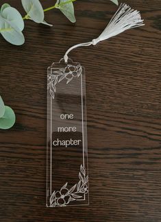 a clear acrylic bookmark with the words one more chaper on it