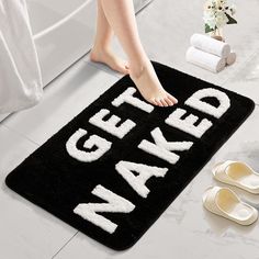 a black mat with the words naked on it and two pairs of shoes next to it