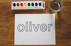 a piece of paper with the word olliver written on it next to some water and paints