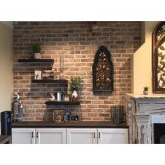 a brick wall in a kitchen with white cabinets