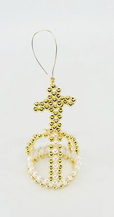 an ornament made out of beads with a cross on it