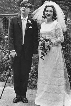 an old black and white photo of a man and woman in wedding attire standing next to each other