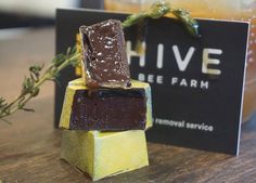 three pieces of chocolate sitting on top of a wooden table next to a black sign