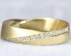 a gold wedding band with diamonds on it