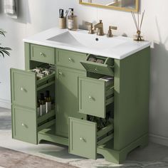 a bathroom sink sitting under a mirror next to a green cabinet with drawers underneath it