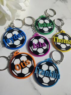 six personalized key chains with soccer balls and names on them, all in different colors