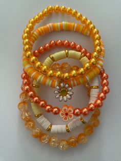 Pretty Stylish bracelets you can stack with others or wear individually! ✨ Great for any occasion✨ ✨ Makes a perfect gift as well✨ ✨Each set is unique ✨ When putting on the bracelet don't stretch them to much 💖✨ Be sure to check out my store✨💖 Orange Stackable Bracelets With Round Beads, Stackable Orange Round Beaded Bracelets, Adjustable Orange Stackable Beaded Bracelets, Adjustable Stackable Orange Beaded Bracelets, Orange Flower Jewelry For Beach, Orange Flower-shaped Jewelry For Beach, Yellow Stackable Bracelets As Gift, Orange Flower-shaped Beach Jewelry, Yellow Stackable Bracelet As Gift