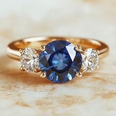 a three stone ring with blue and white diamonds